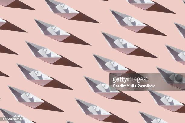 repeated paper boat on the pink background - origami boat stock pictures, royalty-free photos & images