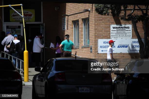 People wait in line to enter a California Department of Motor Vehicles office on May 08, 2020 in San Francisco, California. The California DMV has...