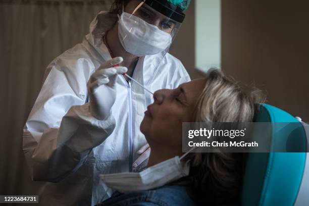 Woman reacts before having a COVID-19 nose swab test done at the Kartal Dr. Lutii Kirdar Education and Research Hospital on May 08, 2020 in Istanbul,...