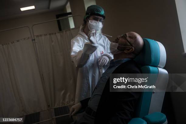 Man reacts before having a COVID-19 nose swab test done at the Kartal Dr. Lutii Kirdar Education and Research Hospital on May 08, 2020 in Istanbul,...