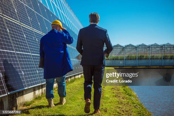 two male engineers at a solar panel site - eco house stock pictures, royalty-free photos & images