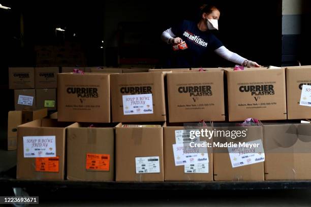 Volunteer assembles boxes of food for families as part of the "Soup-R Bowl" at Gillette Stadium on May 08, 2020 in Foxborough, Massachusetts. The...
