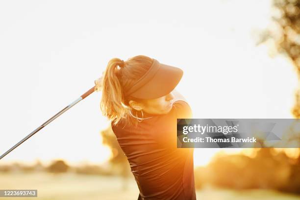 woman hitting drive during early morning round of golf - golf swing imagens e fotografias de stock