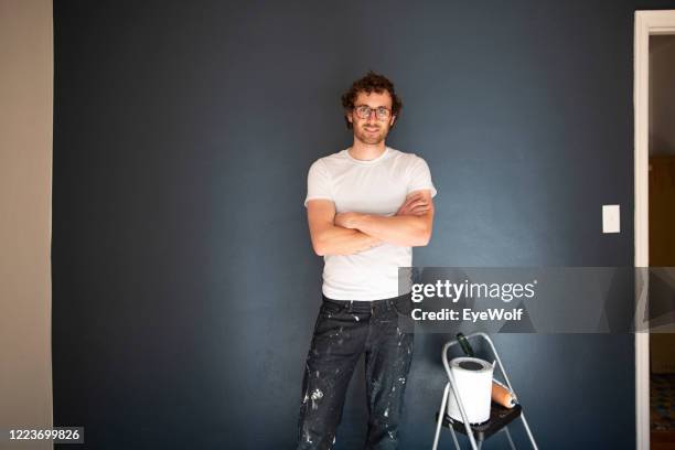 horizontal portrait of a young man getting ready to paint, looking at camera. - farbeimer stock-fotos und bilder