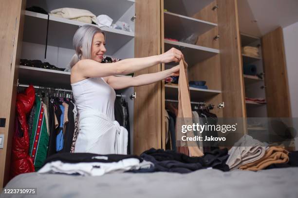 vrouw die haar garderobe in haar slaapkamer reorganiseert - change socks stockfoto's en -beelden