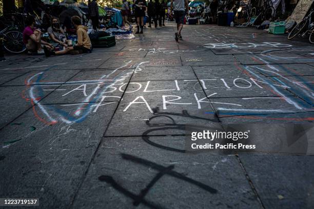 Spray painted vandalism is seen as hundreds of protesters occupy the space around City Hall, awaiting details on how Mayor Bill de Blasio proposes to...