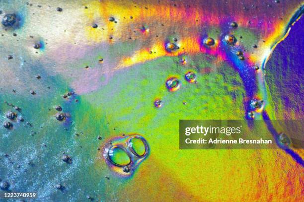 holographic oil slick, close-up - olielek stockfoto's en -beelden
