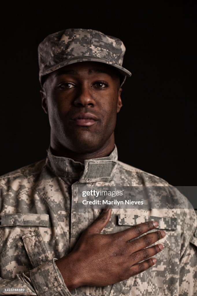 Black soldier in uniform with hand on heart