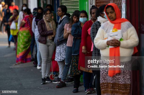 Indian students and members of the Indian community queue for free food parcels at a local restaurant prepared by the Malayalee Association of the...