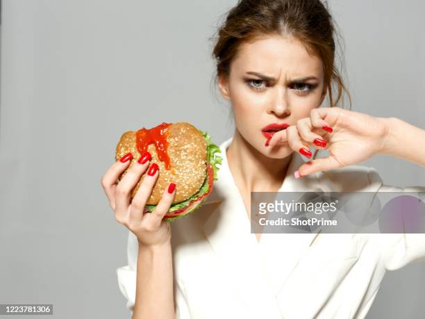 woman bit off a hamburger in which hot chili sauce. - chili woman ストックフォトと画像