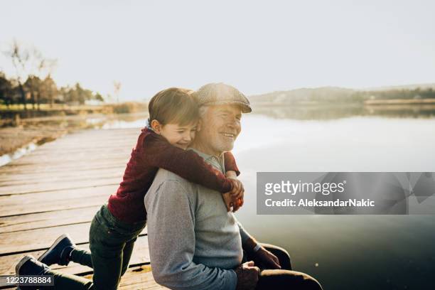 grandfather and grandson on a lake dock - grandfather stock pictures, royalty-free photos & images