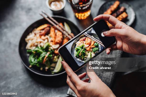 mãos de cozinhar fotografando prato vegano asiático - fotografar - fotografias e filmes do acervo