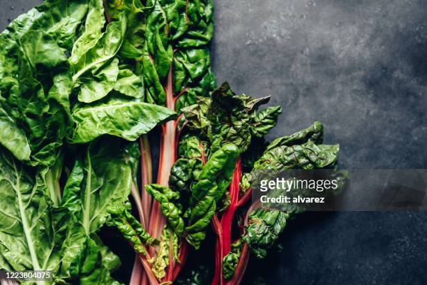 spinach and chard leaves on black background - leaf vegetable stock pictures, royalty-free photos & images
