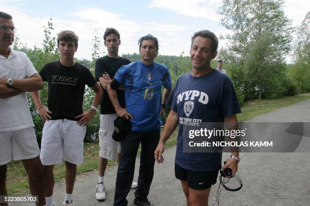 French President Nicolas Sarkozy speaks to journalists 13 August 2007 during his morning jog on the shore of Lake Winnipesaukee in Wolfeboro, New...