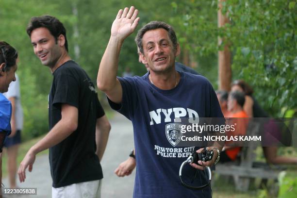 French President Nicolas Sarkozy speaks to journalists 13 August 2007 during his morning jog on the shore of Lake Winnipesaukee in Wolfeboro, New...