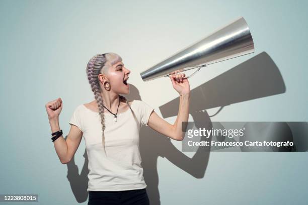 woman using a megaphone - megaphone fotografías e imágenes de stock