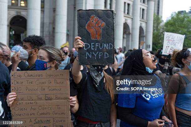 Protester is seen displaying placard reading "Defund NYPD" during the protest outside of City Hall. Tensions increase ahead of a City Council vote on...