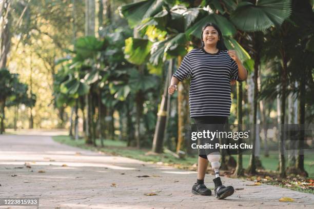 asia indian female amputee with prosthetic leg exercising at public park - patrick walker stock pictures, royalty-free photos & images