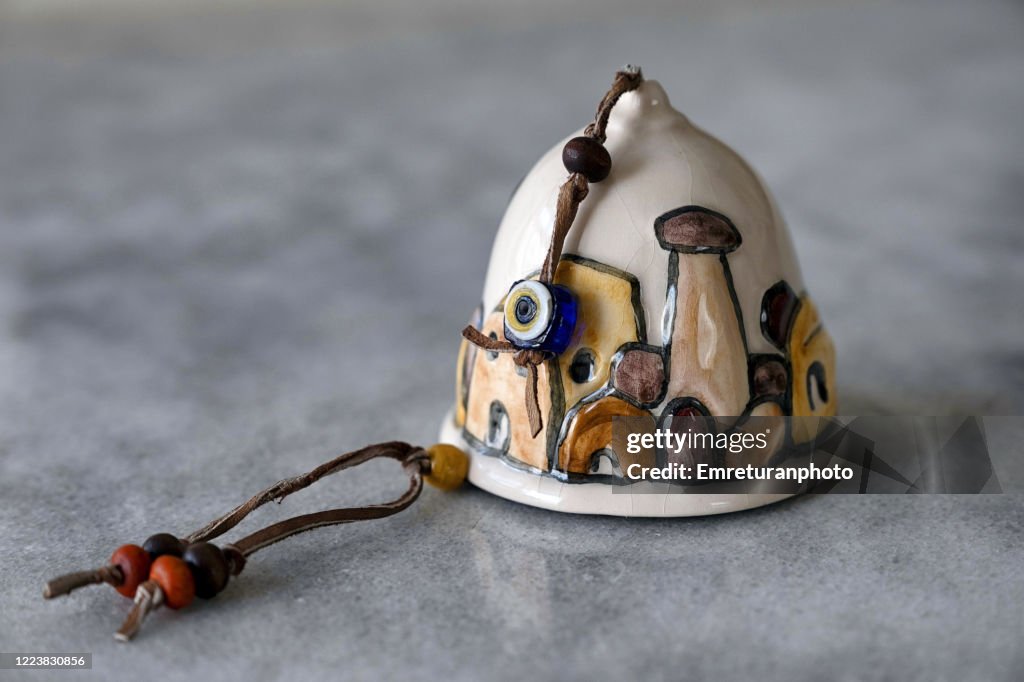 Close up of a ceramic bell on gray table top .