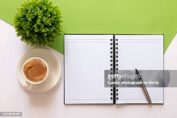 note pad, pen, cup of latte milk and potted plant on multi colored background - books and book open nobody imagens e fotografias de stock