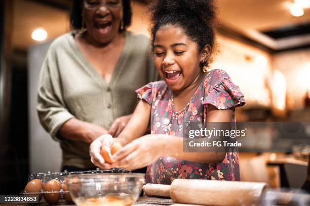 grandmother and granddaughter cooking at home - milk family stock pictures, royalty-free photos & images