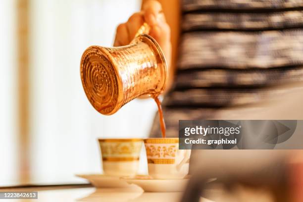 young woman preparing turkish coffee in the kitchen - turkish coffee stock pictures, royalty-free photos & images