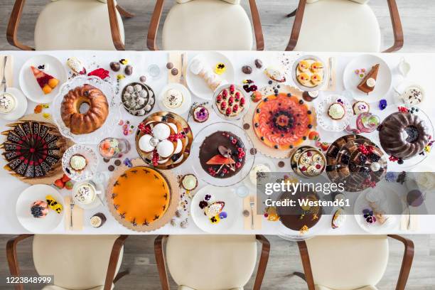 directly above view of dining table filled with all kinds of snacks and desserts - cake table stock pictures, royalty-free photos & images