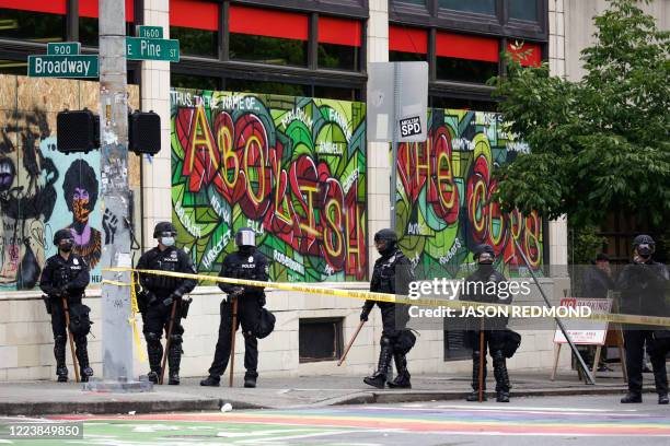 Graffiti that reads "abolish the cops" is pictured as Seattle Police block entrance to the Capitol Hill Occupied Protest after clearing it and...