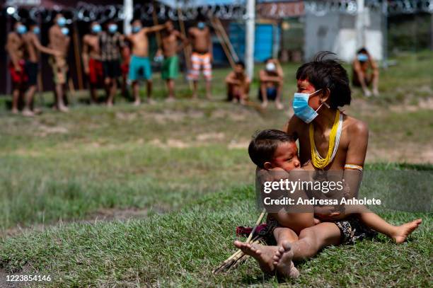 Yanomami indigenous breastfeeds her infant as arriving to receive health care during the Yanomami / Raposa Serra do Sol Mission amidst at the...