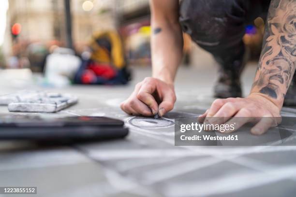 street art, pavement artist drawing an eye on pavement and using smartphone - street artist stock pictures, royalty-free photos & images