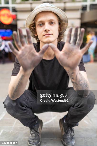 street art, pavement artist showing his dirty hands - street artist stock pictures, royalty-free photos & images