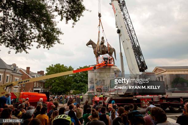 People watch as the Stonewall Jackson statue is removed from Monument Avenue in Richmond, Virginia on July 1, 2020. - Workers in Richmond, Virginia,...