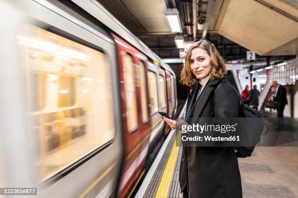 portrait of confident woman at the subway station, london, uk - station stock-fotos und bilder