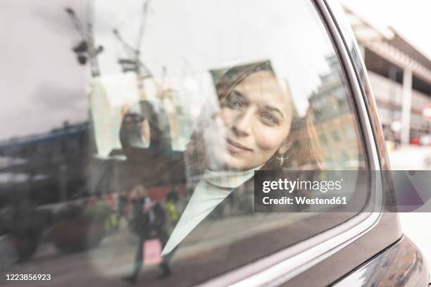 woman in the rear of a taxi looking out of the window, london, uk - london taxi stock-fotos und bilder