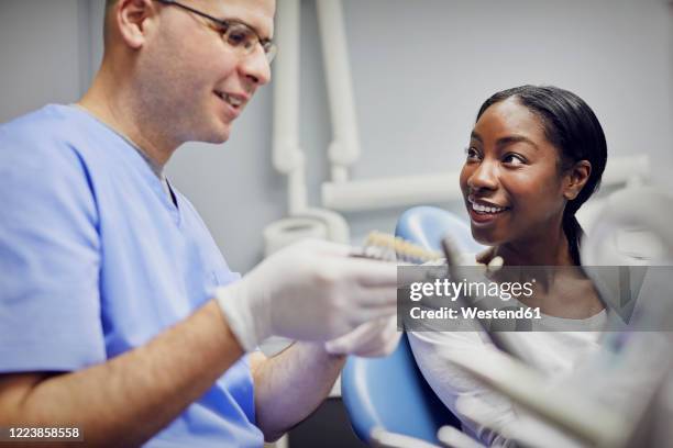 patient getting dental teeth whitening treatment - a male dentist stock pictures, royalty-free photos & images