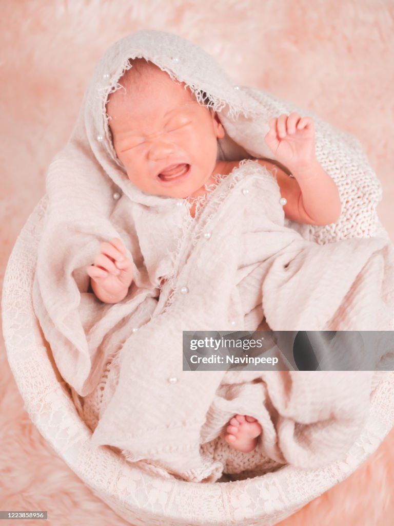 Newborn baby photography, wrapped in beige robe, bath wear