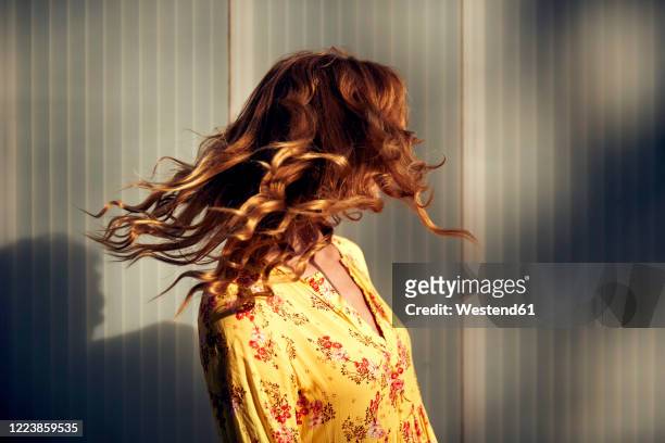 red-haired woman shaking her hair - langes haar stock-fotos und bilder