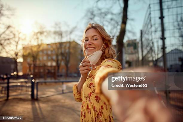 red-haired woman wearing a ffp2 face mask in the city - beauty launch stock pictures, royalty-free photos & images