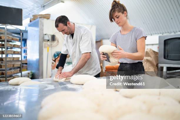 man and woman preparing loaves of bread in bakery - bakning business bildbanksfoton och bilder