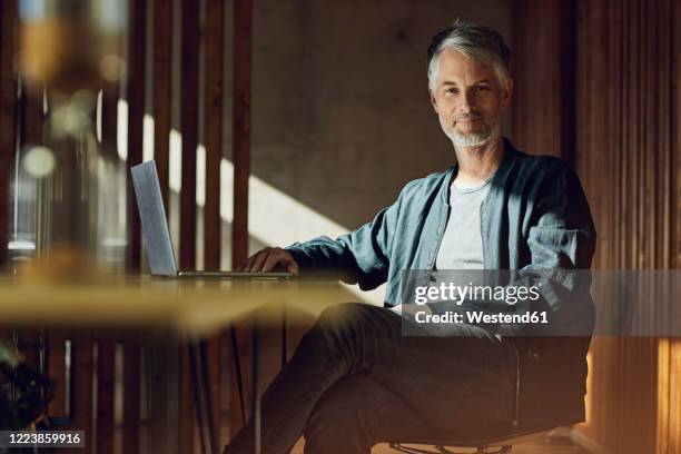 casual businessman sitting in his sustainable office, looking at camera - table of content stock pictures, royalty-free photos & images