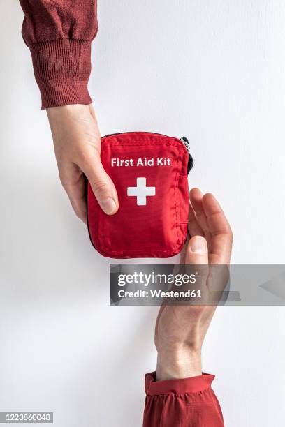 overhead view of woman handing over first aid kit to man - first aid kit bildbanksfoton och bilder