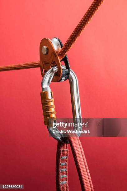 climbing carabiner on harness loop and rope through pulley - carabiner stock pictures, royalty-free photos & images