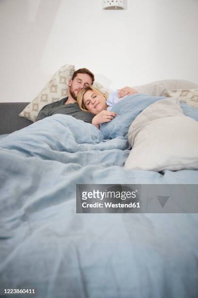 couple sleeping in bed - paar kuscheln bett stock-fotos und bilder