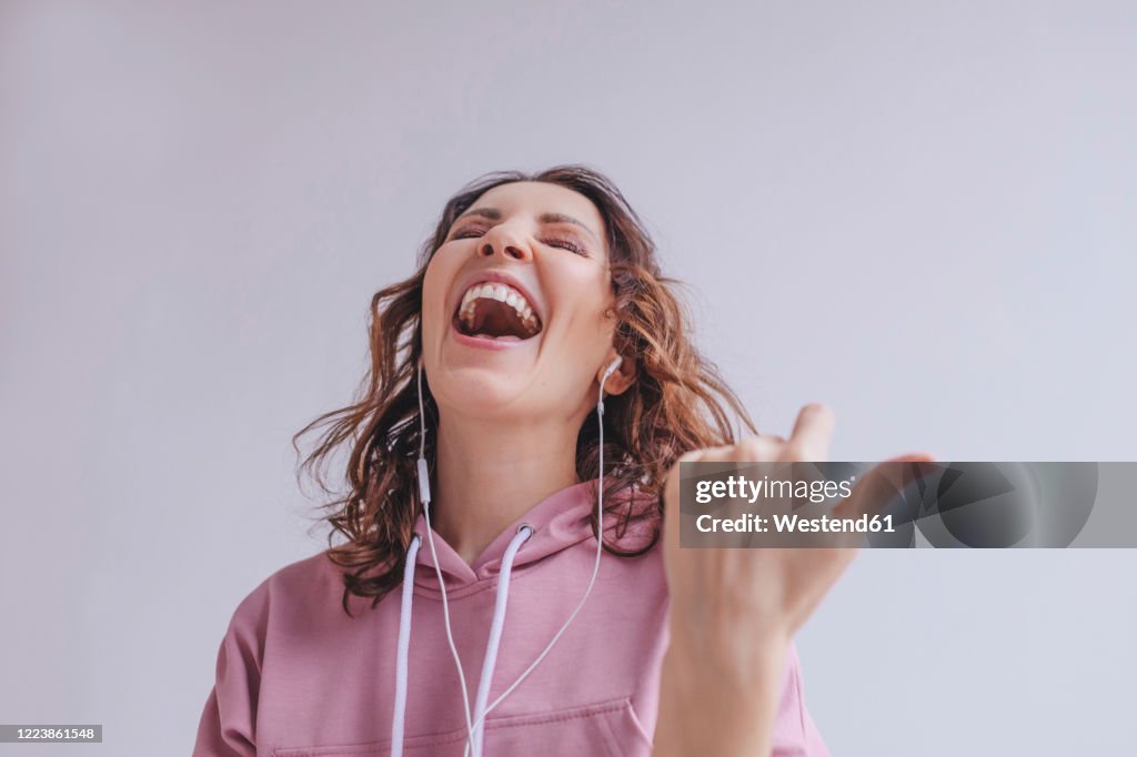 Brunette woman listening to music and singing