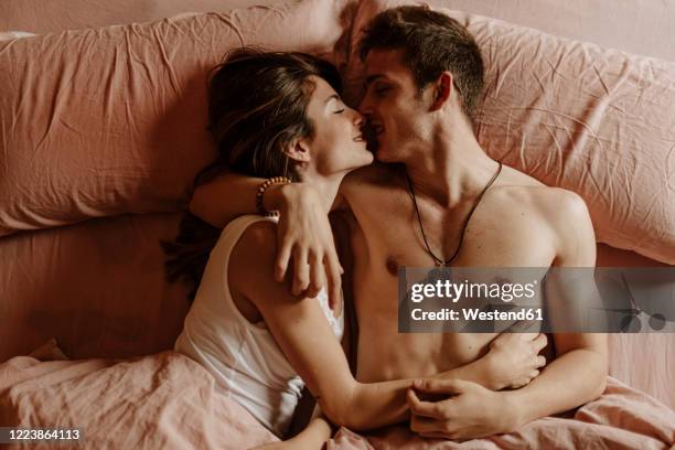 intimate young couple lying in bed - 性交 ストックフォトと画像