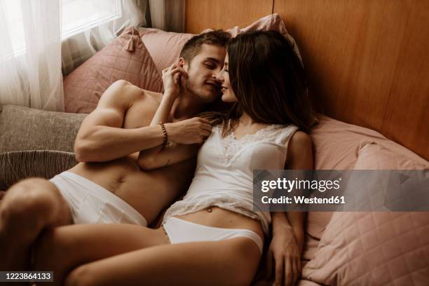 intimate young couple lying in bed - couple lust stock-fotos und bilder