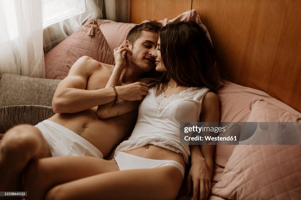 Intimate young couple lying in bed