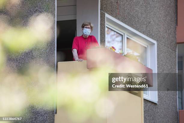 senior woman wearing mask on balcony, retirement home - coronavirus quarantine stock pictures, royalty-free photos & images