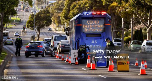 Police pull vehicles aside at a checkpoint in the locked-down suburb of Broadmeadows in Melbourne on July 2, 2020. - Around 300,000 people in...