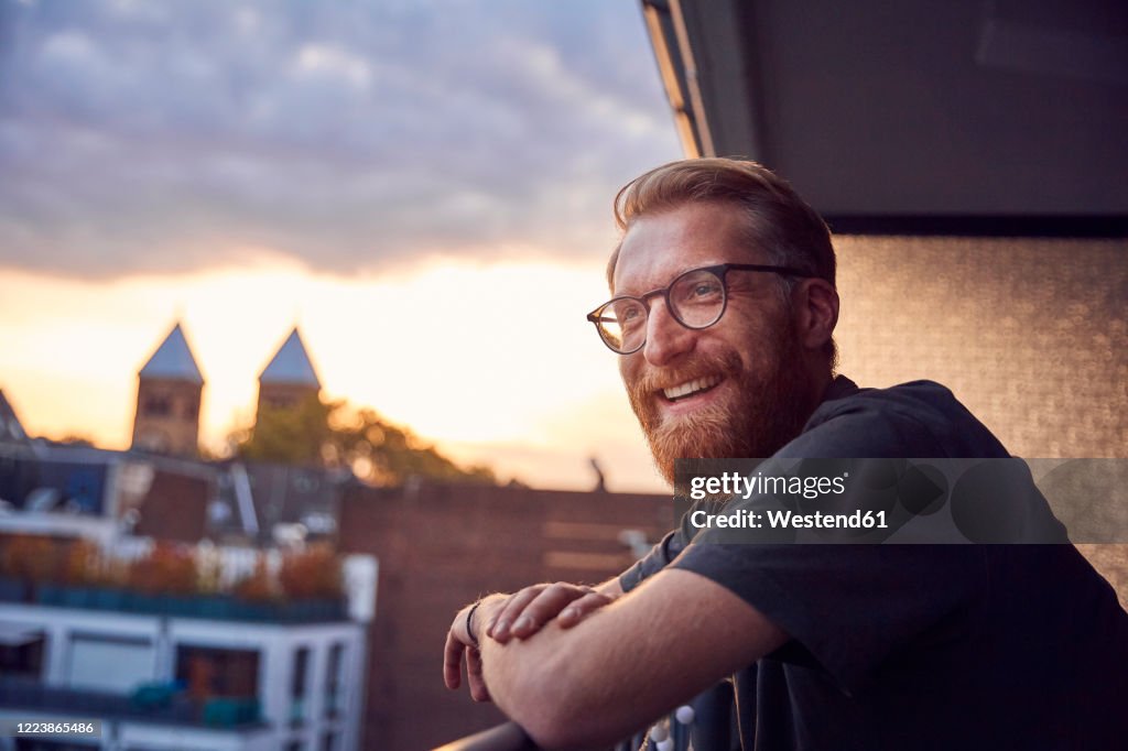 Portrait of relaxed man on balcony looking at distance